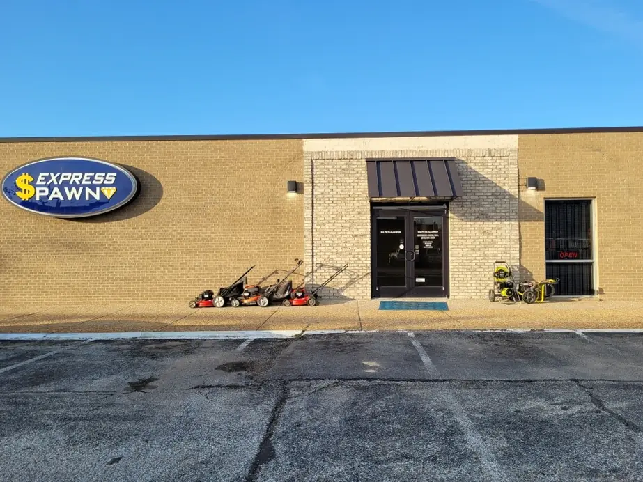 Express Pawn Paragould storefront in daylight, lawn mowers and pressure washers for sale by the door